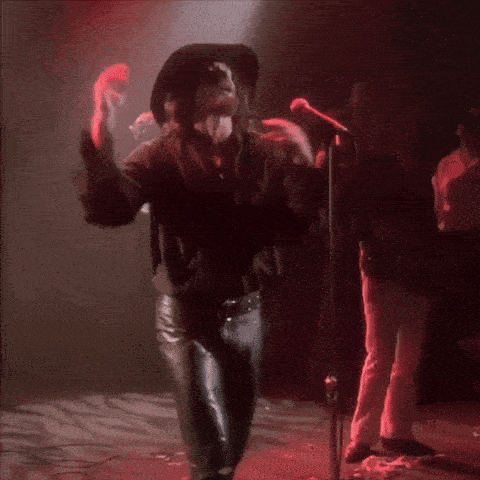 a man in a cowboy hat sings into a microphone