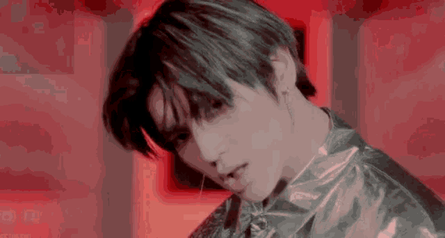 a close up of a person 's face with a red background .