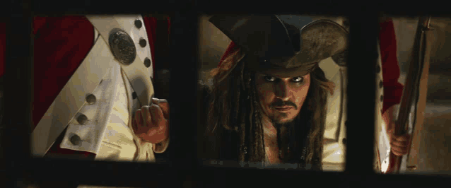 a man in a pirate hat is looking through a fence