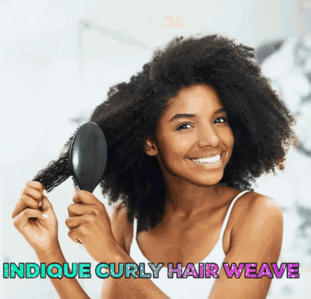 a woman is smiling while brushing her curly hair with the words indicque curly hair weave below her