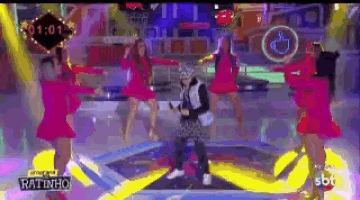 a group of women are dancing in front of a man on a stage that says ratinho
