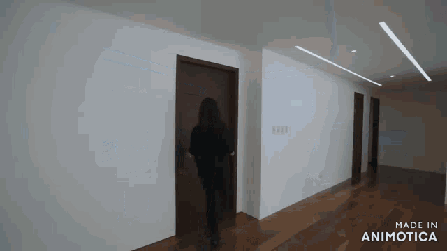 a woman walking down a hallway with the words made in animotica on the bottom right