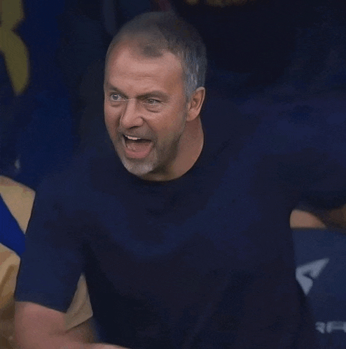 a man in a blue shirt is making a face with his mouth open