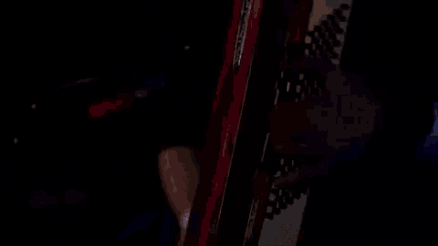 a close up of a person playing an accordion in a dark room