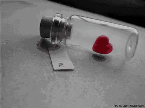 a small bottle with a small red heart in it and a tag that says " to "