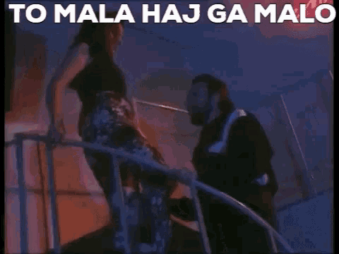 a man and a woman are standing on a balcony with the words to mala haj ga malo written above them