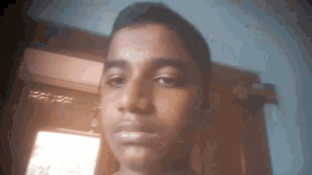 a young boy looks at the camera with a serious expression on his face
