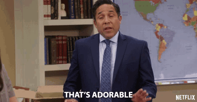 a man in a suit and tie says that 's adorable in front of a map