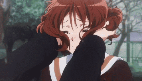 a girl with red hair is crying with her hand on her face