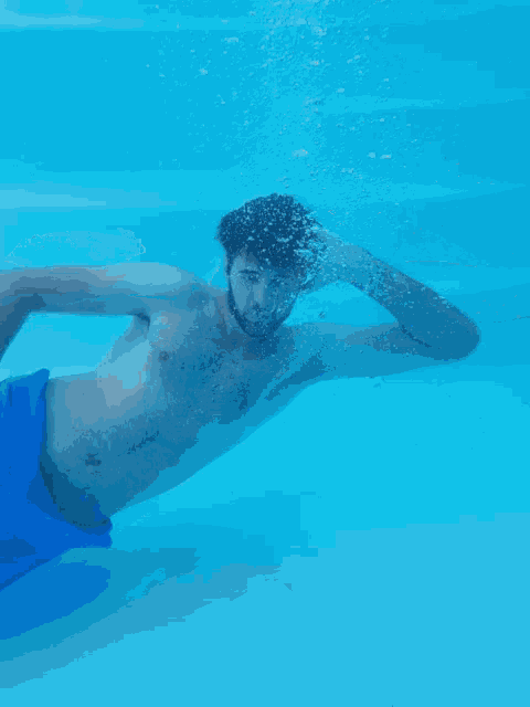 a man and a woman are swimming in a pool and the woman has a tattoo on her arm that says " i love you "