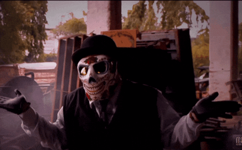 a man wearing a skeleton mask and a top hat is standing in front of a sign that says m2
