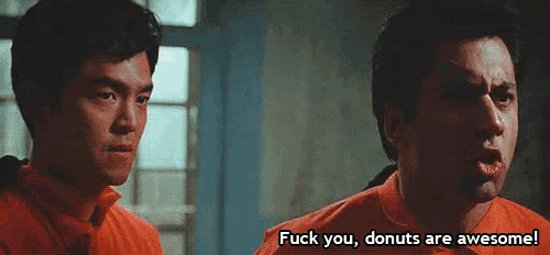 two men in orange jumpsuits are standing next to each other .