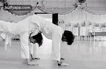 a couple of men are doing yoga together in a room .