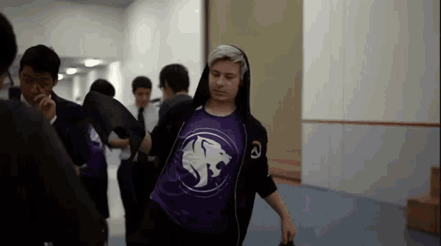 a man in a purple shirt with a white lion on it
