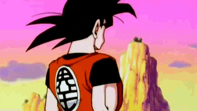 goku from dragon ball z is standing in front of a mountain and looking at something .