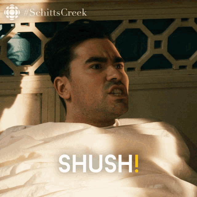 a picture of a man laying in bed with the word shush on the bottom right