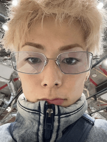 a person wearing glasses and a jacket with a zipper
