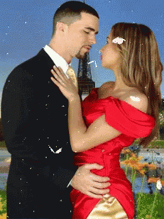 a man in a suit and a woman in a red dress are kissing in front of the eiffel tower
