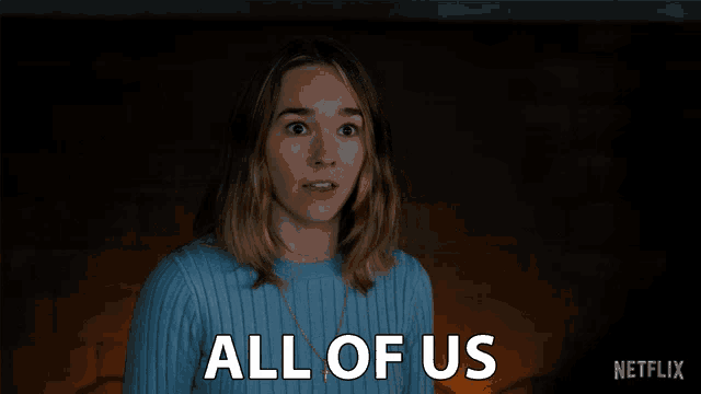 a woman in a blue sweater says " all of us " in white letters