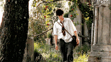 a young man in a white shirt and tie is walking in a field