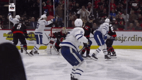 a hockey game is being played in front of a sign that says hard rock