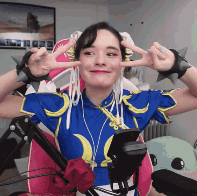 a woman wearing a chun li costume is giving a peace sign