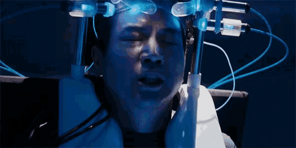 a man is laying in a chair with his eyes closed and a machine on his head