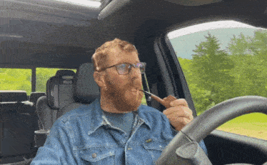 a man smoking a pipe in a car with a seat that says ford on it