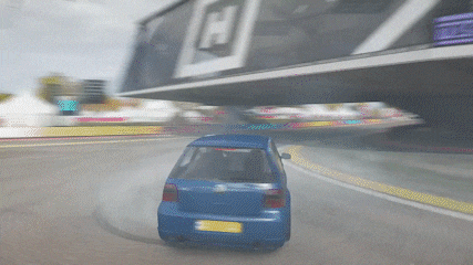 a blue car is driving down a road in front of a building that says h