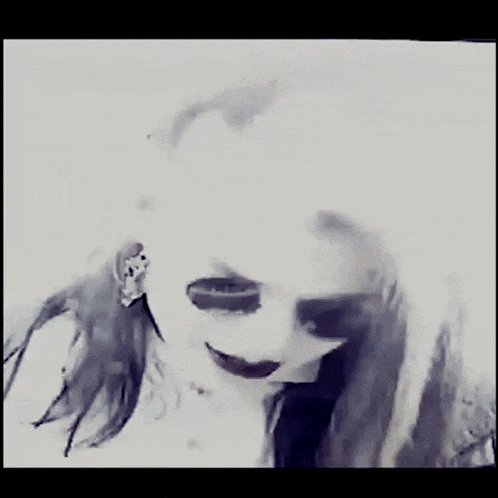 a black and white photo of a woman wearing a mask and sunglasses