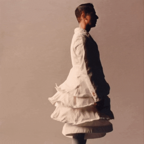a man in a white dress with ruffles on it