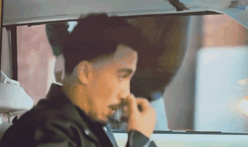 a man with a beard is sitting in the back seat of a car