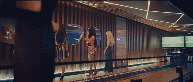a group of women are standing on a bowling alley and one of them has the number 1 on her shirt