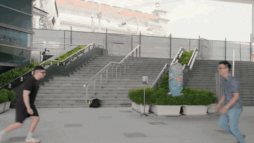 two men are running in front of a staircase with a sign that says ' stairs ' on it
