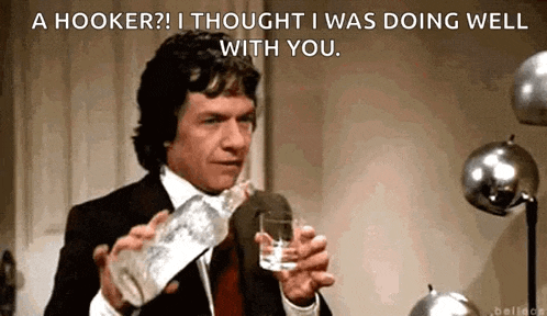 a man in a suit is pouring a glass of water from a bottle ..