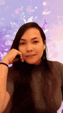 a woman with long hair is taking a selfie in front of a purple background with butterflies and flowers