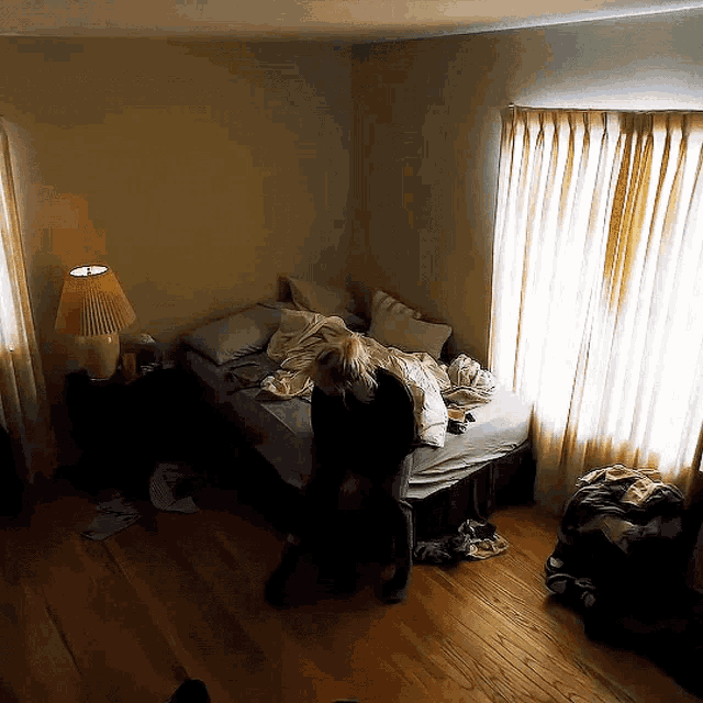 a bedroom with a bed and a lamp on the window