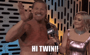 a man without a shirt is standing next to a woman holding a microphone .