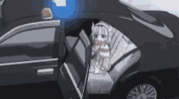 a girl is sitting in the back seat of a police car with the door open .