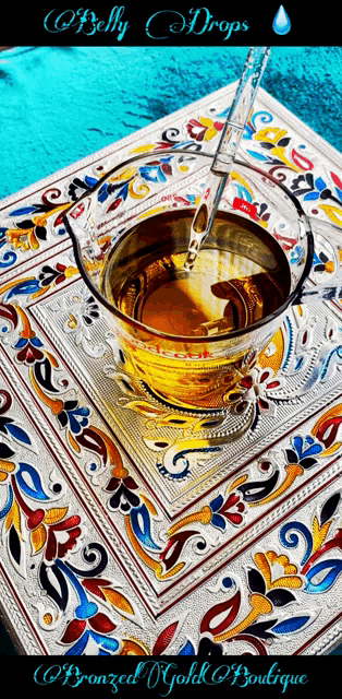 a cup of belly drops sits on a colorful tablecloth