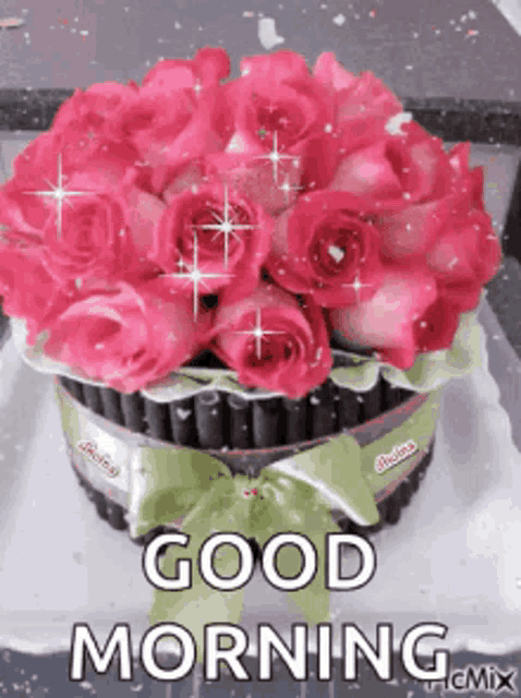 a bouquet of pink roses on a cake with the words `` good morning '' written on it .