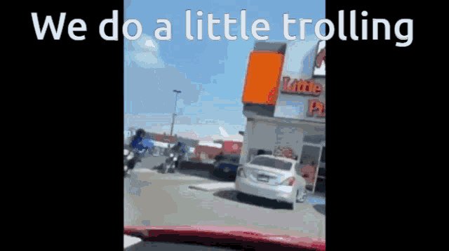 a car is parked in front of a little caesars restaurant .