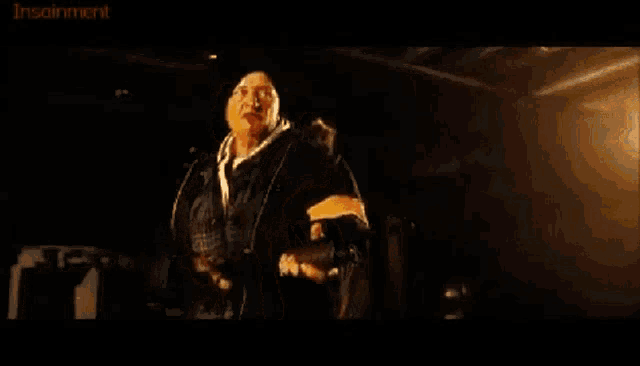 a man is standing in front of a fireball in a movie scene .