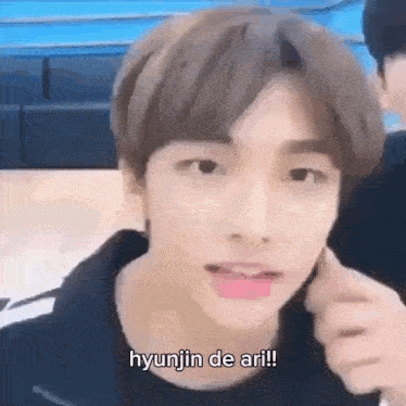 a close up of a person 's face with the words `` hyunjin de ari '' on it .