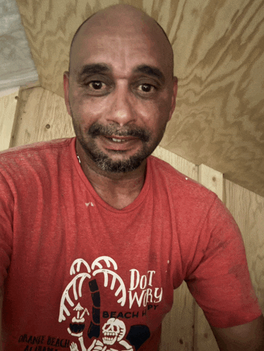 a man wearing a red shirt that says dot why
