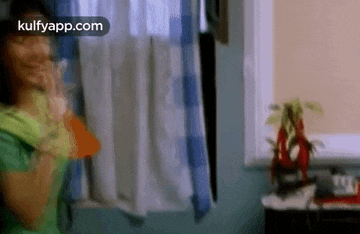 a woman is standing in front of a window in a room .