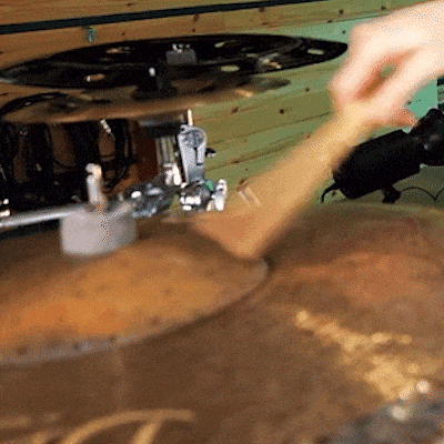 a person is playing a drum set with a cymbal that says t on it