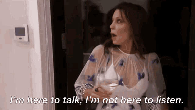 a woman with a glass of wine says i 'm here to talk i 'm not here to listen