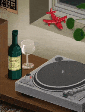 a bottle of wine sits next to a record player and a glass of wine