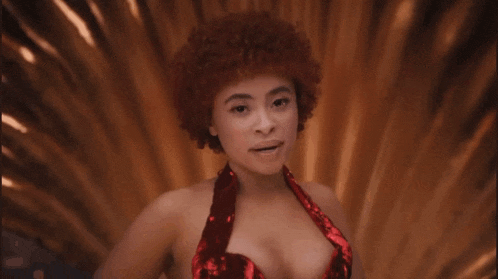 a woman with red curly hair is wearing a red dress